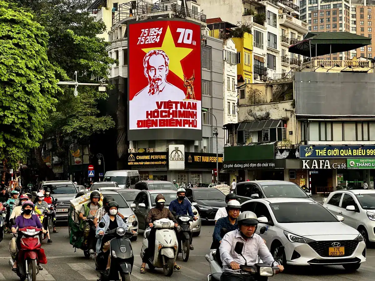 Affiche de propagande de Hô Chi Minh au-dessus du trafic de scooters à Hanoï