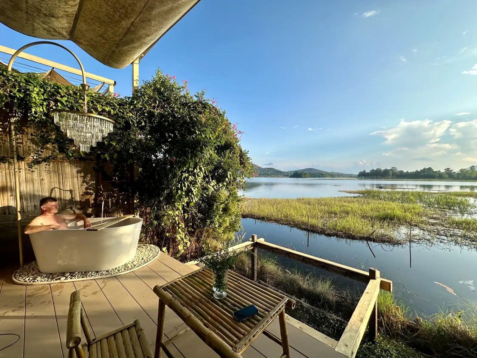 Baignoire face au lac devant une bulle de glamping près de Chiang Rai