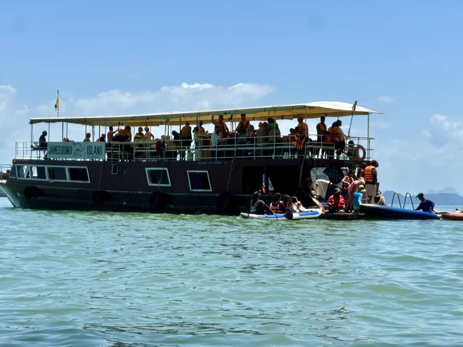 Grand bateau d'excursion en bois avec ses kayaks au mouillage à Ko Panak, baie de Phang Nga