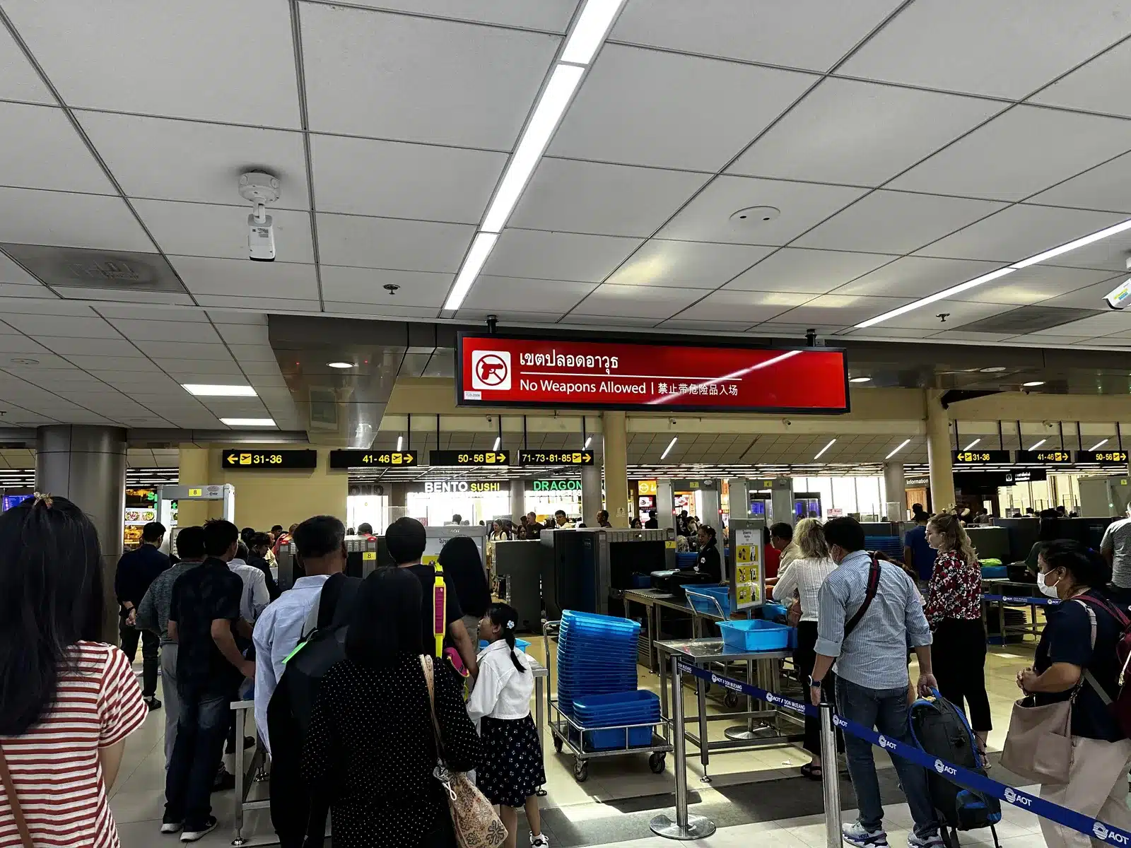 Contrôle de sécurité avec un panneau d'interdiction des armes à l'aéroport de Don Mueang, Bangkok