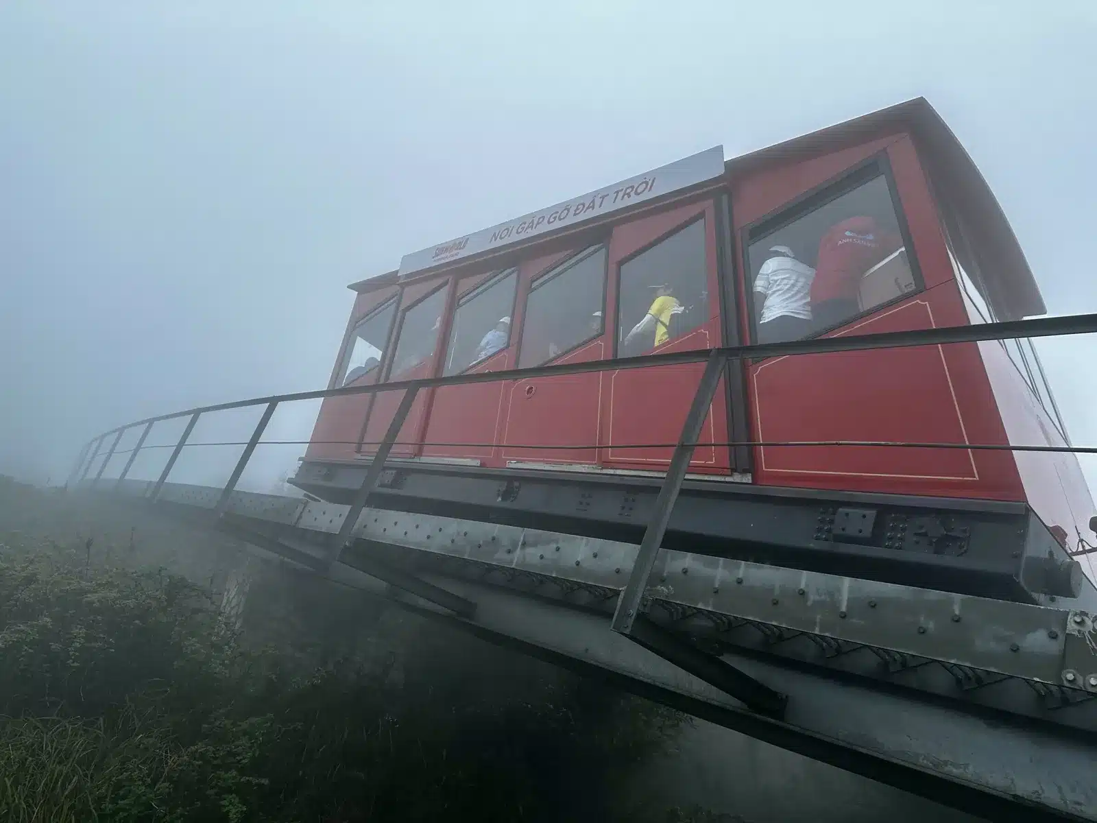 Funiculaire rouge vers le sommet du Fansipan sur sa voie dans la brume