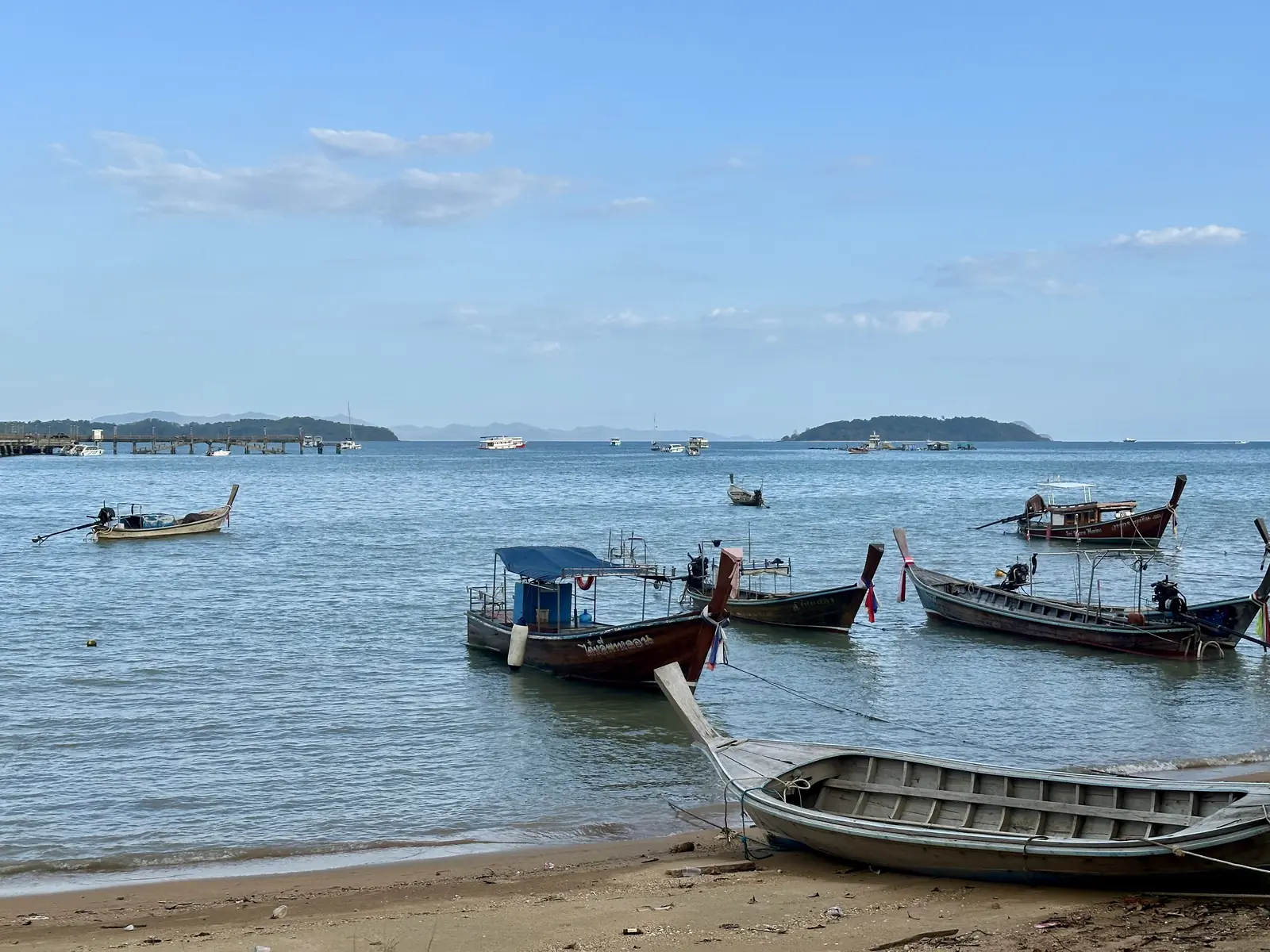 Bateaux longtail sur la plage à côté d'Ao Por Pier, Phuket