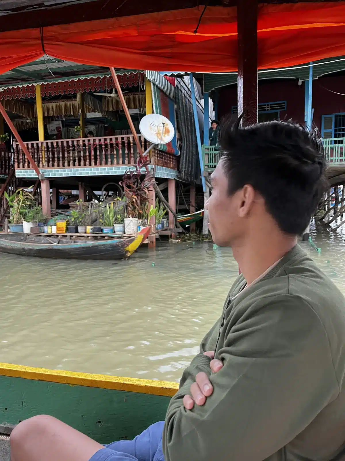 Roy dans un bateau devant un restaurant flottant sur pilotis à Kampong Phluk